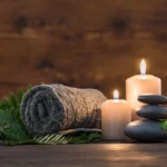 Rolled towel, candles and stones prepared for a massage at Caju Knots