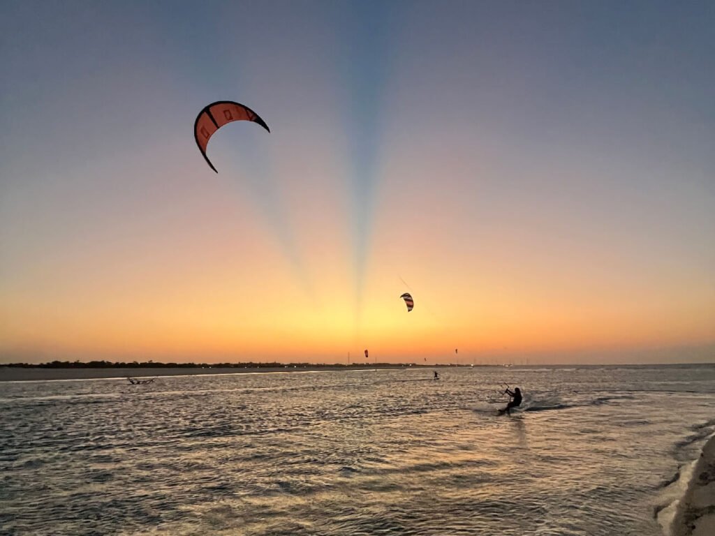 Kitesurfers riding at sunset on the flat water of Parajuru, Ceará, Brazil