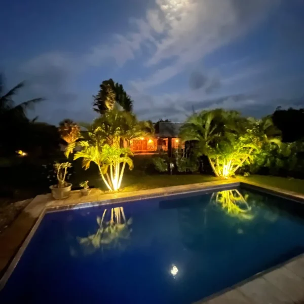 Pool and garden lit up at night at Caju Knots