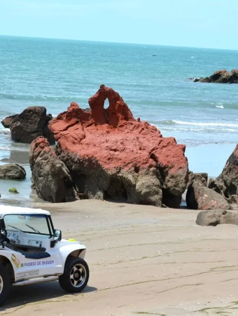 Beach buggy in front of the red cliffs of the Ceará coast